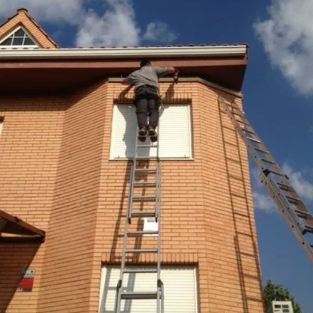 Hombre subiendose a una escalera arreglando casa
